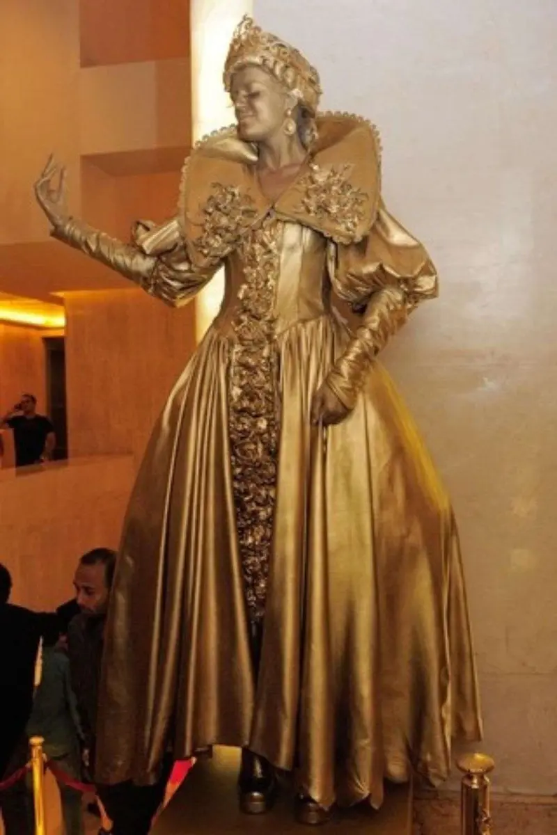 Gold living statue in a baroque gown welcoming guests at an event in a Dubai hotel